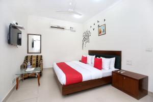 a bedroom with a bed and a desk and a tv at Super OYO Hotel Supreme in Chandīgarh