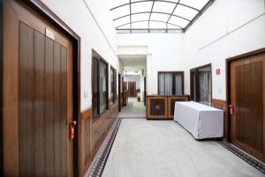 a hallway with wooden doors and a white refrigerator at Super OYO Hotel Supreme in Chandīgarh