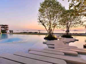 a row of trees sitting in the middle of a pool at Veranda Residence/1BR/25th floor in Na Jomtien