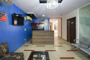 a living room with a blue wall and a chair at OYO Flagship Karnal Royal in Karnal