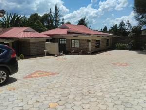 a house with a car parked in front of it at Comfort Guest House in Kericho