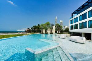 a large swimming pool next to a building at Veranda Residence/1BR/25th floor in Na Jomtien