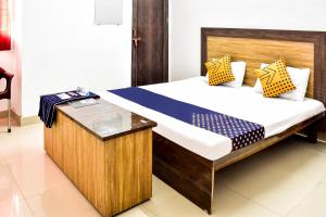 Bett in einem Zimmer mit einem Bettrahmen aus Holz in der Unterkunft SPOT ON City Tower Inn in Jāmul
