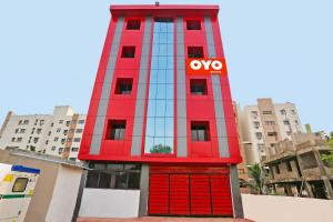 a red building with the omg sign on it at Capital O Hotel Aryan in Khandagiri