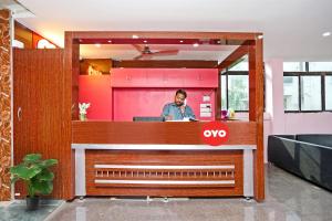 a man standing at a counter in a restaurant at Capital O Hotel Aryan in Khandagiri