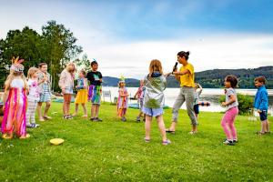 a group of children playing frisbee in the grass at Amenity Hotel & Resort Lipno in Lipno nad Vltavou