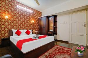una camera da letto con un grande letto con una coperta rossa di Flagship South Fort Inn a Alleppey
