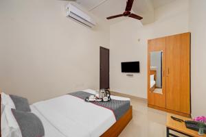 1 dormitorio con 1 cama y TV en Super Townhouse 999 INN24 Airport en Chennai