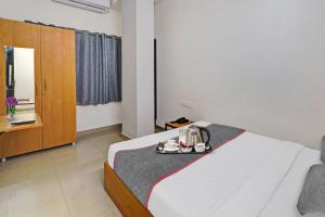 a hotel room with a bed with a tray on it at Super Townhouse 999 INN24 Airport in Chennai