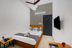 a hotel room with a bed and a tv at Townhouse 999 INN24 Airport in Chennai