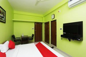 Bārang的住宿－OYO Ms Plaza，一间卧室配有一张床和一台平面电视