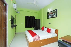 Bārang的住宿－OYO Ms Plaza，一间卧室设有一张带绿色墙壁的床