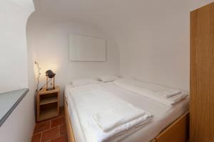 a bedroom with a white bed with a night stand at Apartma Jenkova rezidenca in Kranj