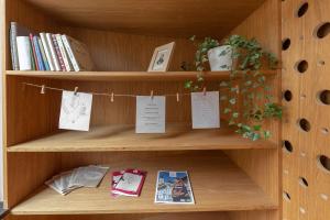 a book shelf with books and papers on it at Apartma Jenkova rezidenca in Kranj