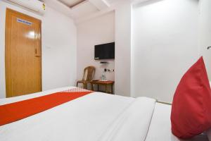 a bedroom with a bed and a tv on the wall at Airport Comfort Stay in Garui