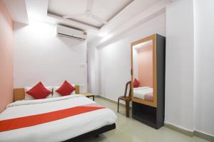 a bedroom with a bed and a mirror at Airport Comfort Stay in Garui