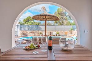 a table with wine glasses and an umbrella at Villa Abril in Santanyi