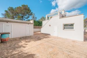 a white house with a driveway in front of it at Villa Abril in Santanyi