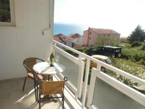 a table and chairs on a balcony with a view of the ocean at Apartments Bandalo in Podstrana