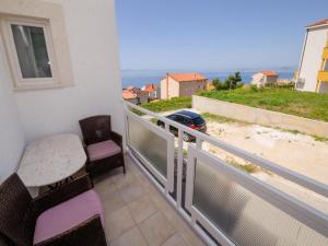 d'un balcon avec une table et des chaises et une vue sur l'océan. dans l'établissement Apartments Bandalo, à Podstrana