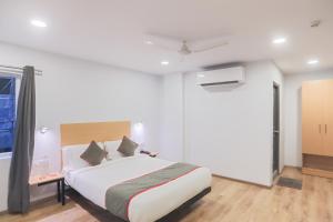 a bedroom with a large white bed and a window at Townhouse 143 Hotel Royal Garden Near park Street Mullick bazar crossing in Ballygunge