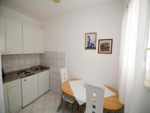 a small kitchen with a table and a table and chairs at Apartments Bandalo in Podstrana