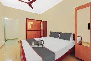 a bedroom with a bed with a phone on it at Collection O Arn Guest House Near Chennai International Airport in Chennai