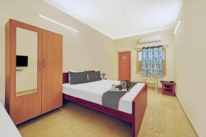 a bedroom with a bed and a sliding door at Collection O Arn Guest House Near Chennai International Airport in Chennai