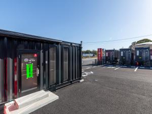 una fila de casas móviles en un estacionamiento en HOTEL R9 The Yard Koge, en Nakatsu