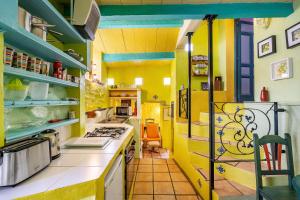 uma cozinha com paredes amarelas e balcões brancos em El Nido holiday cottage with pool em Órgiva