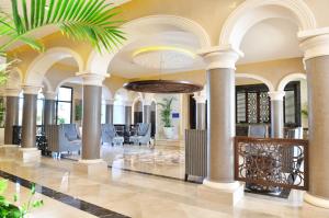 a lobby of a hotel with columns and chairs at JAZ Aquamarine in Hurghada +92 photos