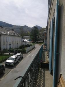 a balcony of a building with cars parked on a street at Beau studio avec balcon in Bagnères-de-Bigorre