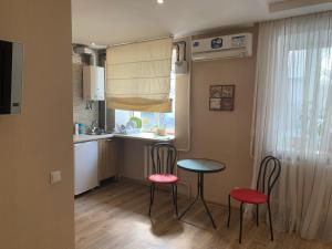 eine Küche mit 2 Stühlen, einem Tisch und einem Waschbecken in der Unterkunft Апартаменты на пр Гагарина in Dnipro