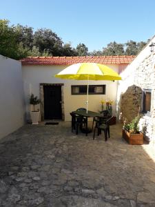 Casa Hozani في Albarrol: فناء بطاولة ومظلة صفراء