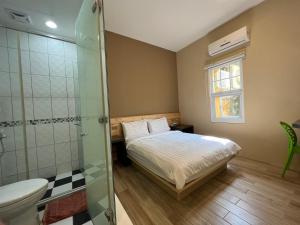 a bedroom with a bed and a glass shower at 好樣的民宿 in Xiaoliuqiu