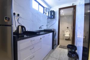 - une cuisine avec un lavabo et des toilettes dans la chambre dans l'établissement Sarkar Chambers, à Mumbai