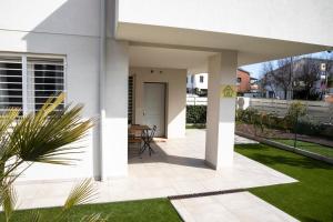 Casa blanca con patio y césped en Maisonette Modena Park en Módena