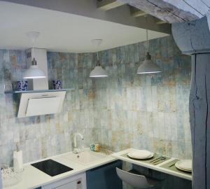una cocina con dos luces colgantes y un lavabo en La Casa Rebonita PICCOLA en Candelario