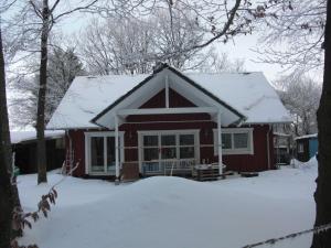 une maison rouge avec de la neige sur le toit dans l'établissement Ferienwohnung Studiowohnung, offener Wohn- und Schlafber, à Langgöns