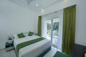 a bedroom with a bed and a large window at The Elms Thekkady in Thekkady