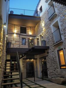un gran edificio de piedra con escaleras y balcón en La Casa Rebonita PICCOLA en Candelario