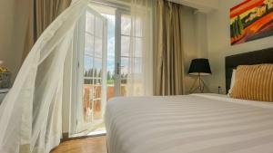 a bedroom with a bed and a large window at Via Appia Tagaytay in Tagaytay