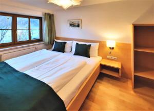 um quarto com uma grande cama branca e uma janela em 103 m2 Apartment EschenWald vomLandl Leogang em Leogang