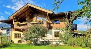 a wooden house with a balcony and a yard at 103 m2 Apartment EschenWald vomLandl Leogang in Leogang