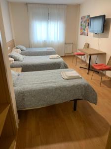 A bed or beds in a room at Pension Valcarce