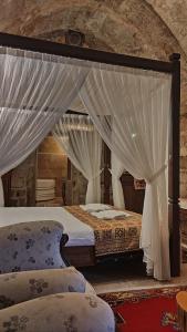 a bedroom with a canopy bed with white curtains at Ürgüp Inn Cave Hotel in Urgup