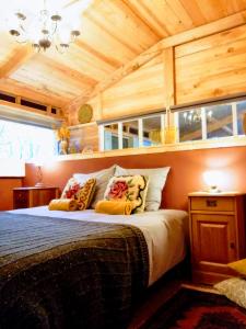 ein Schlafzimmer mit einem Bett in einem Zimmer mit Holzdecken in der Unterkunft De Langenbrinck Eerlijk Heerlijk overnachten in blokhut en ingerichte tent in Breedenbroek