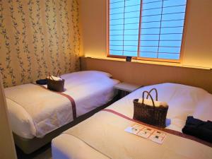 a hotel room with two beds and a window at Tosei Hotel Cocone Kamakura in Kamakura