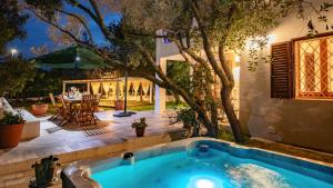 a swimming pool in the backyard of a house with a tree at Casa Valentina 6 Emma Villas in Porto Istana +17 photos