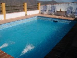 - une piscine avec de l'eau bleue et des chaises bleues dans l'établissement House 6 Bedrooms with Pool and WiFi 8798, à Almáchar